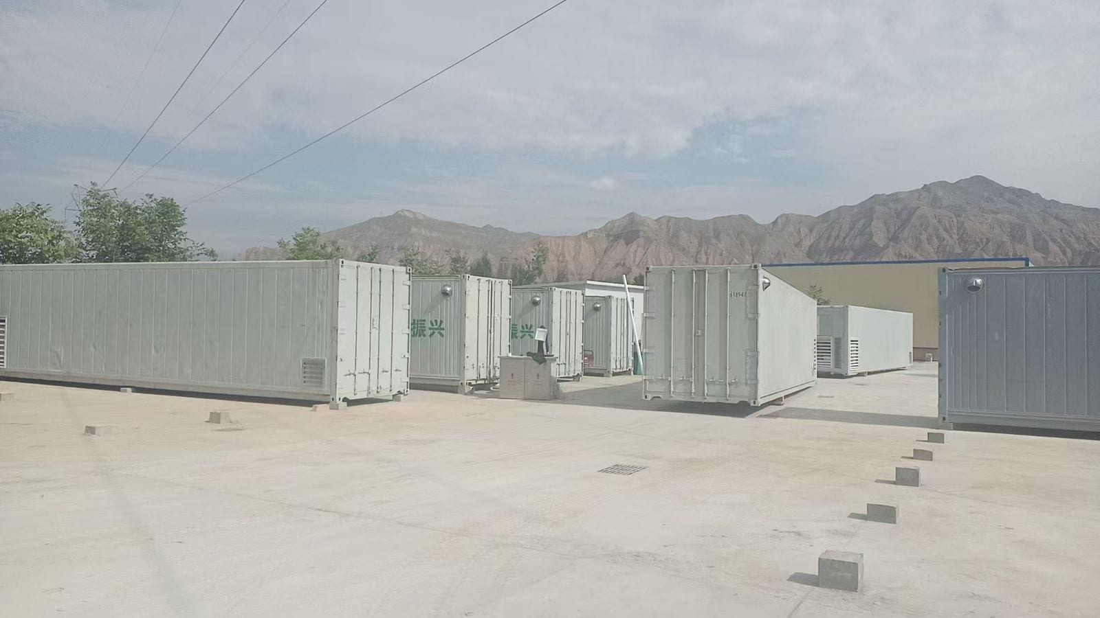 Tibet project site: eight 40ft mushroom cultivation cabins lined up on the plateau, backed by mountains